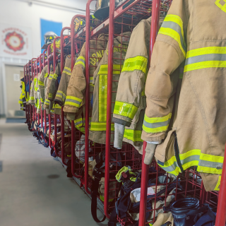 a line of hanging fire department uniforms