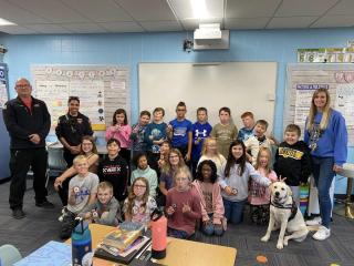 Hope the Therapy Dog posed with a classroom full of kids