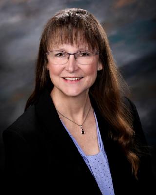 photo of Michell in black jacket and lavendar shirt
